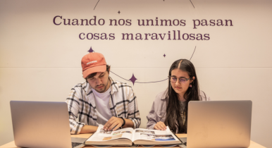 Dos estudiantes jóvenes de periodismo analizando un libro