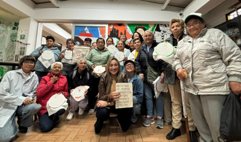 Estudiantes de Utadeo junto a las mujeres de la tercera edad a quienes les dan el taller de tejido Estudiantes de Utadeo posan junto a un grupo de adultas mayores con quienes comparten en un taller de tejido